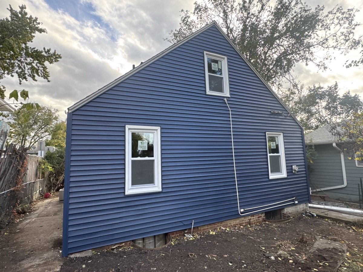 Complete siding replacement rejuvenates aging home exteriors. A residential home with brand-new siding panels installed from ground to soffit. width=
